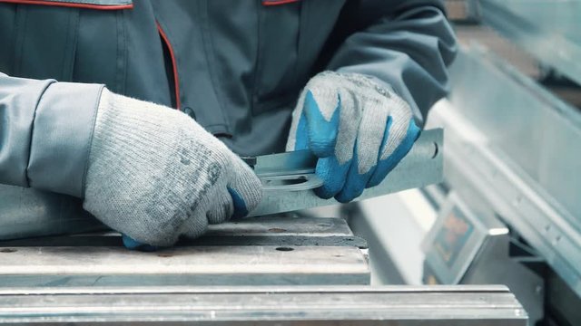 Engineer measuring angle at metal product by goniometer. Measuring angle