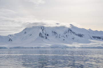 Fototapeta na wymiar Antarctic mountain with low hanging clouds