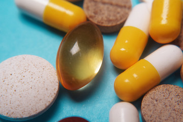 Pills on a blue background. Assorted pharmaceutical medicine pills, tablets and capsules, health...