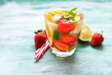 Sweet water and strawberry slices, mint leaves, lime and lemon. Glass of refreshing soft drink with fresh fruits.