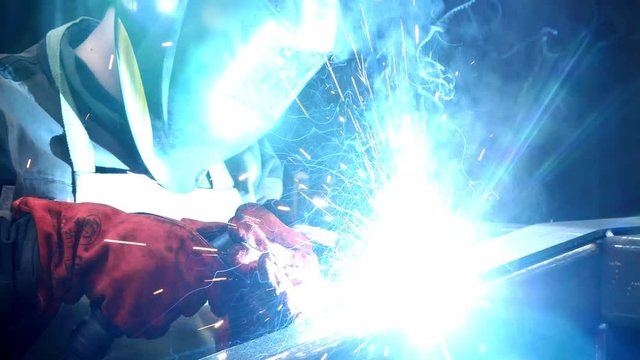 Welder working with electrode at semi-automatic arc welding