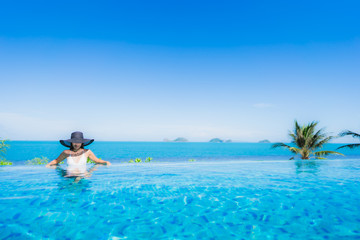 Portrait beautiful young asian woman relax in luxury outdoor swimming pool in hotel resort nearly beach sea ocean