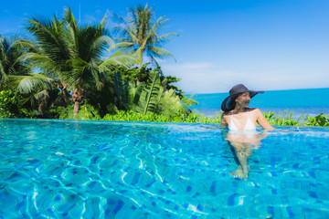 Portrait beautiful young asian woman relax in luxury outdoor swimming pool in hotel resort nearly beach sea ocean