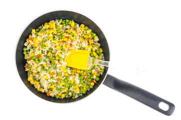 Stewed rice with corn, green peas in pan on white background. 