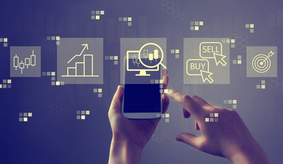 Stock trading theme with person holding a white smartphone