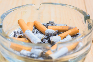 Transparent ashtray full of cigarette butts