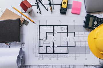 Architect house plan roled -up plans on the table, high angle view.