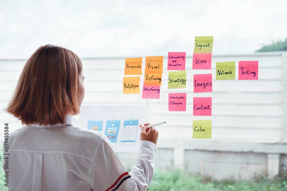 Wall mural young creative mobile application developer working with mobile template design screen and colorful 