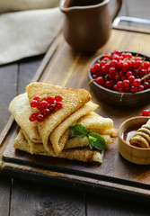 thin pancakes with berries and honey