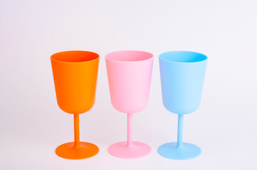 Colored plastic wine glasses on white background.