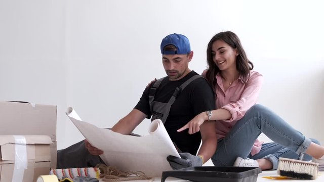 couple looking at architecture plans before starting their renovation in their apartment