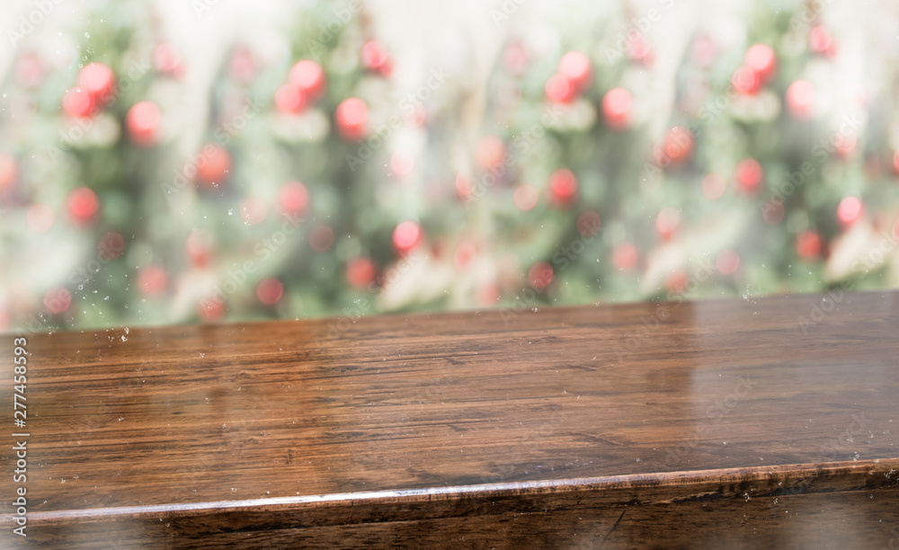 Fototapete wooden table top with abstract blur christmas tree red decor ball and snow fall background with boke