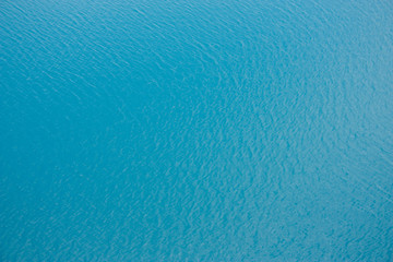 Naklejka na ściany i meble Azure-blue sea water, small ripples. Beautiful abstract background