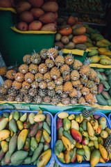 a fruit stand with pineapples, mangoes at the Asian market