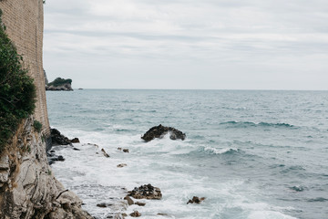 Restless sea near the stone coast. Surf. Natural landscape. Next to the wall of the fortress or fort