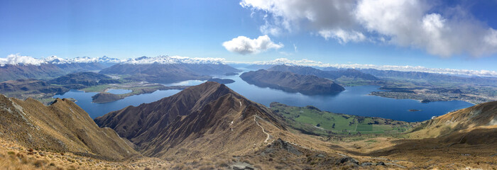 looking down from the mountain peak to Lake Wanaka surrounded by the Southern Alps