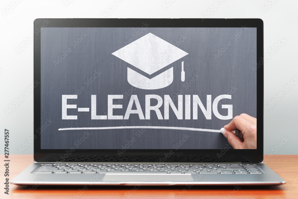 Poster e-learning concept. laptop computer on wooden desk. teacher writing on blackboard. front view image.