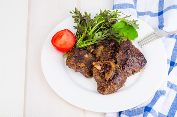 Fried beef liver with lettuce mix. 