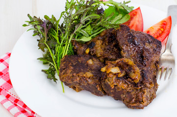 Fried beef liver with lettuce mix. 