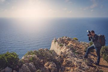 Tourist photographing Navagio Beach and Shipwreck Cove