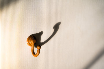 Shadow of the wooden hanger hook White wallpaper wall.soft focus.