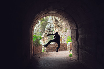 Man practicing karate moves in a tunnel