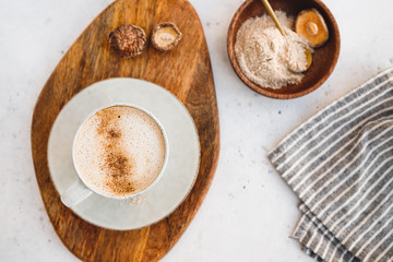 Top view of mushroom latte with Shiitake powder and unsweetened coconut-almond blend milk. Healthy useful vegan drink, flat lay.