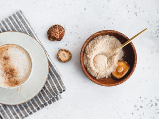 Powder is made from Chinese dried mushrooms Shiitake in a wooden bowl on a table. The concept of medicinal additive for healthy food.