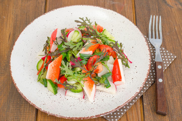 Fresh vegetable salad with crab sticks. 