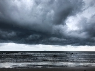 background of dramatic heavy dark clouds over the dark beach