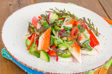 Fresh vegetable salad with crab sticks. 