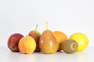 red Apple, pear, lemon, orange, kiwi, peach on white background, copy space