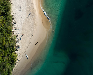 Aerial top view of beach with white sand, beautiful umbrellas and warm turquoise tropical water