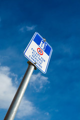 EV - electric vehicle level 2 charging station sign on a pillar with blue sky background. 240V AC station