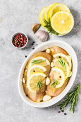 Raw chicken breasts, marinated with lemon garlic rosemary. Top view, space for text.