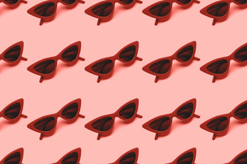 Red sunglasses pattern on blue background. Flat lay. Summer concept. From top view.
