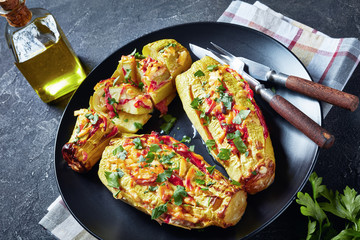 Stuffed courgettes served on a black plate