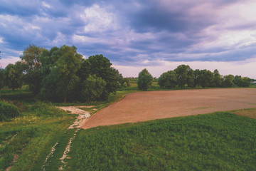 Rural landscape in the evening at sunset.  View from above of plowed field in summer