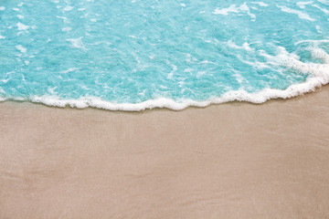 Fototapeta na wymiar Colorful light blue wave on sandy shore nature sea background