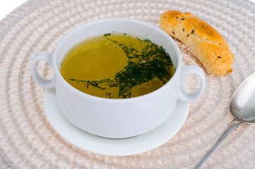 Hot meat broth with fresh cereal bun.