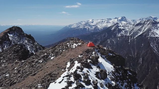 Drone shot orbiting a shelter tent on top of the mountain. Baikal, Siberia
