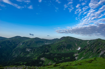 Fototapeta na wymiar Green hills against the blue sky in the mountains