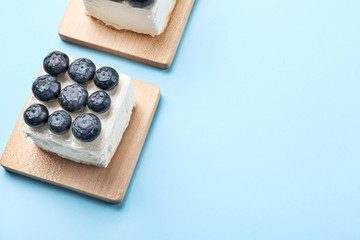 Tasty blueberry cake on color background