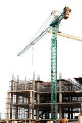 Construction site with green tower crane,shallow depth of field..Concrete foundation of high rise building with full green tower crane in white background,no worker low angle view.