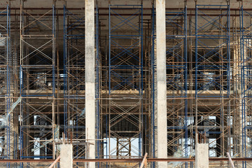 Construction site ,shallow depth of field..Concrete foundation of high rise building with steel scaffolding at sunset,no worker low angle view..