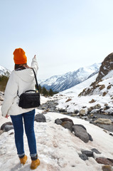 girl standing back over background of winter mountains panorama