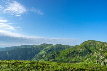 Green hills against the blue sky in the mountains
