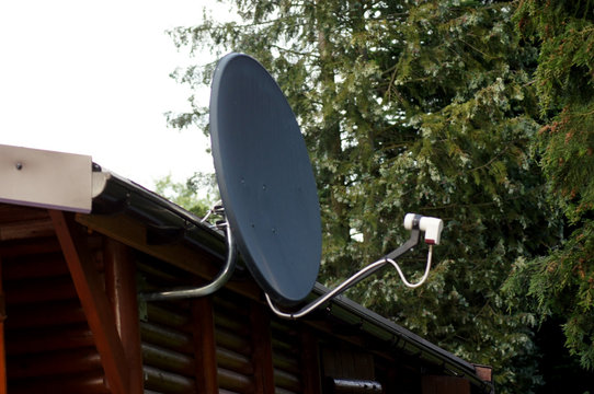 Satellitensch&uuml;ssel an Bungalow aus Holz