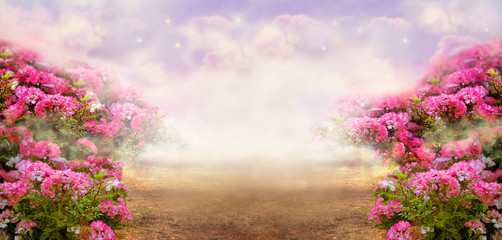 Fantasy summer panoramic photo background with rose field and misty path leading to mysterious glow. Idyllic tranquil morning scene and empty copy space. Road goes across hills to fairytale.