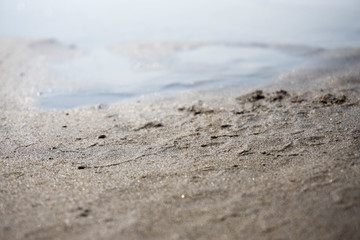Spilled garbage on the beach of a big city. Empty used dirty plastic bottles, children's plastic toys. Dirty sea, sandy coast the Black Sea. Environmental pollution. Ecological problem. Moving waves